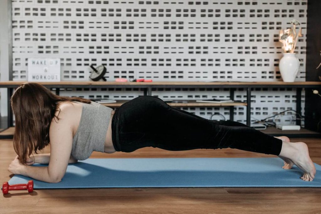 vrouw in sportoutfit is aan het planken voor sterkere buikspieren