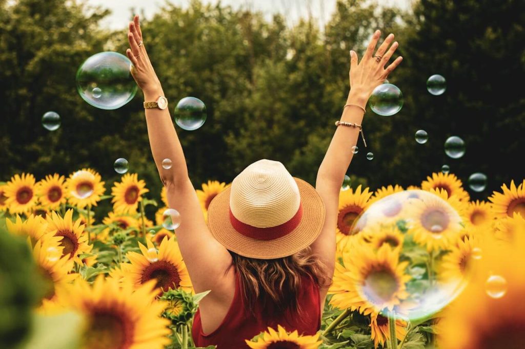 vrolijke vrouw in veld met bloemen