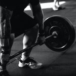 man wil sterker worden door het doen van een oefening met een barbell in de sportschool