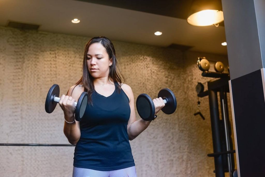 vrouw doet dumbbell bicep curls