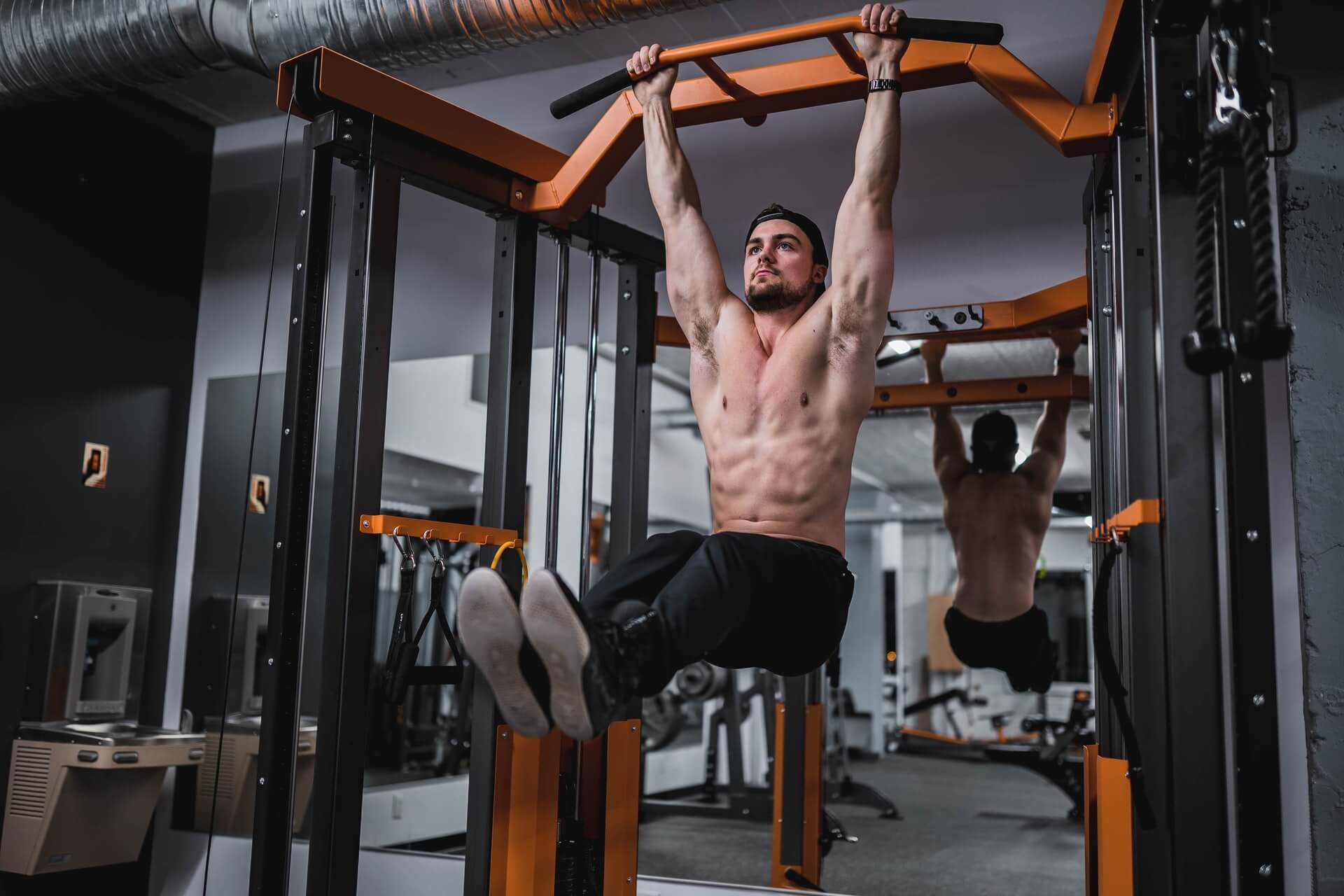 hanging leg raises door een man zonder shirt in de sportschool
