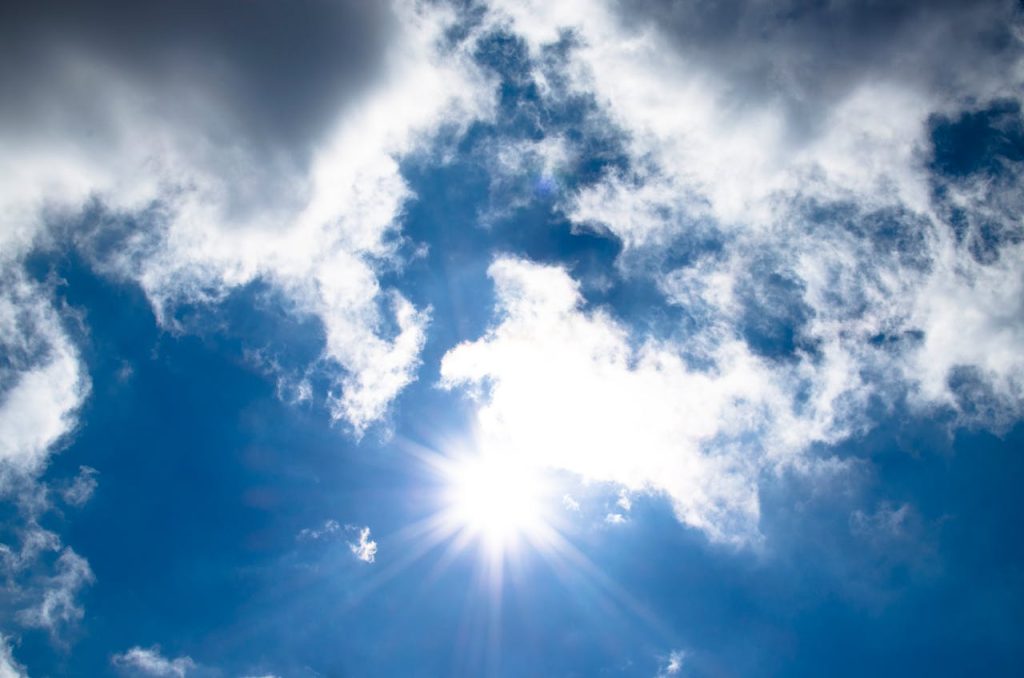 Blauwe lucht met bewolking en de zon