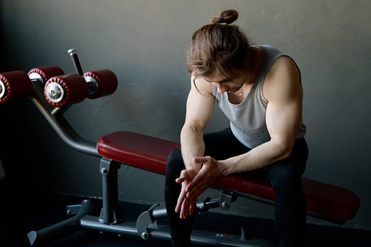 motivatie om te sporten is laag bij persoon met knotje in grijs hemd