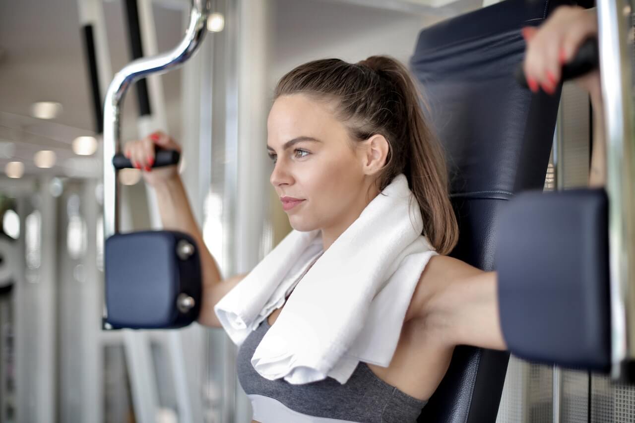 pec deck door een jonge vrouw in de sportschool