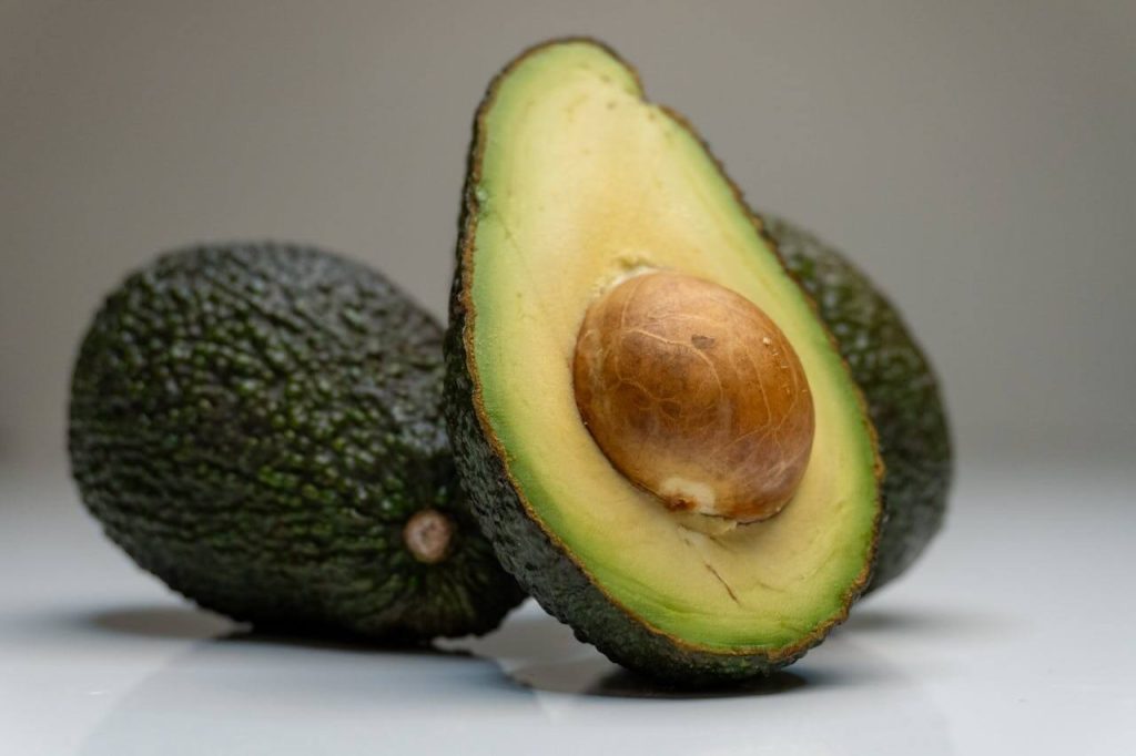 Avocado's waarvan er een doormidden is gesneden