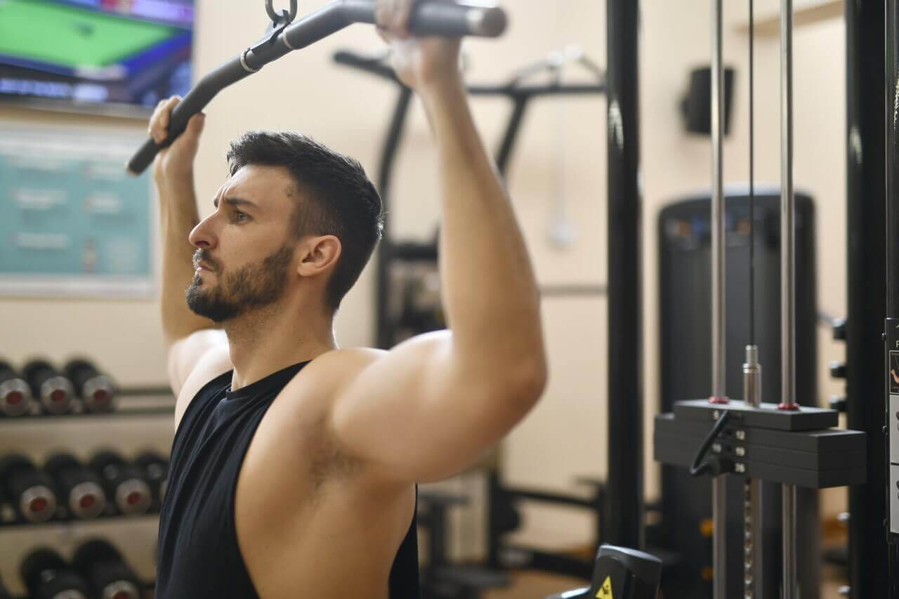 lat pulldown door een man in hemd in de sportschool