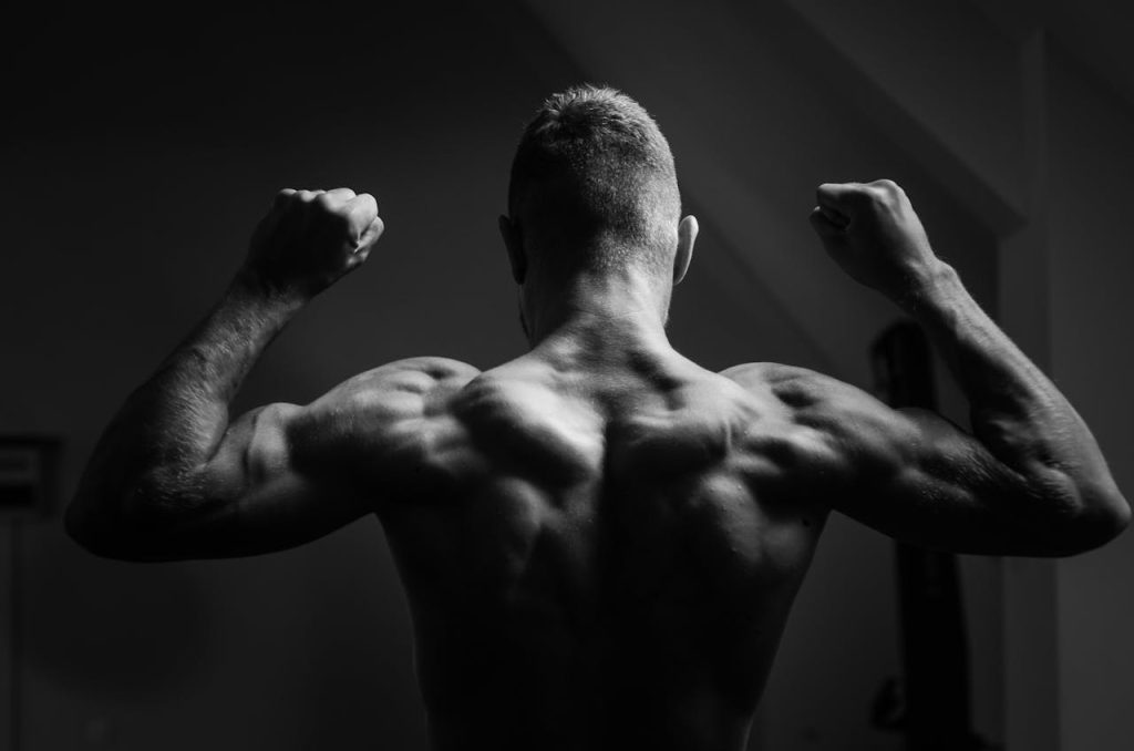 Zwart wit foto van een rug met sterk getrainde trapezius spier