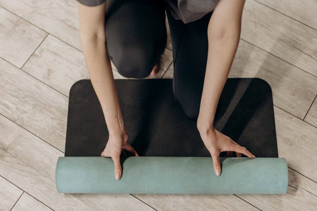 zwarte yogamat wordt uitgerold voor de start van een circuittraining