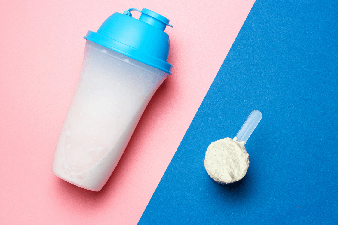 Een shakebeker met een schep eiwitpoeder voor een eiwitshake