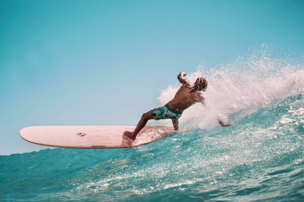 persoon die aan het surfen is en dus buiten aan het sporten is
