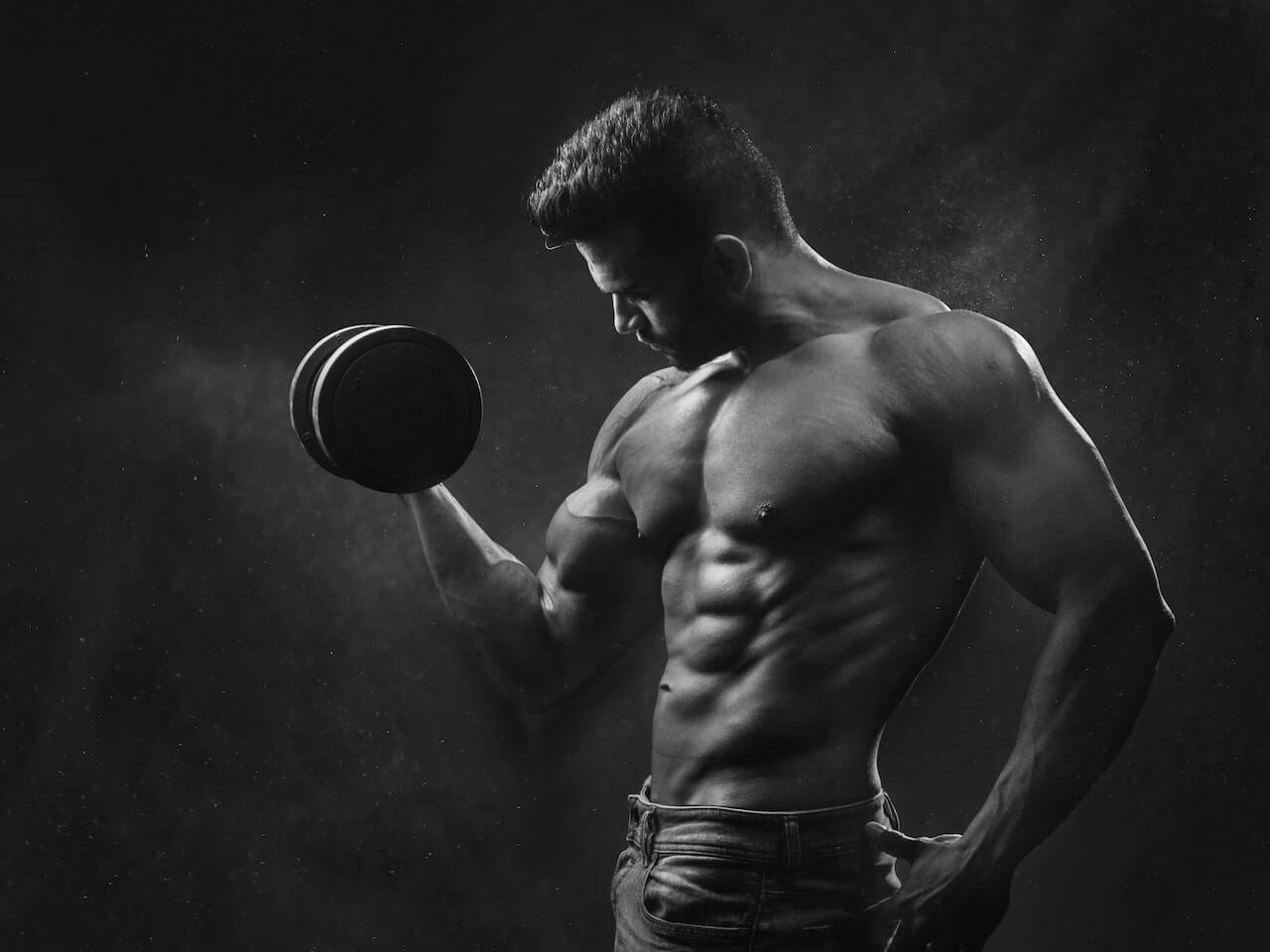 man in de sportschool aan het trainen met een dumbbell