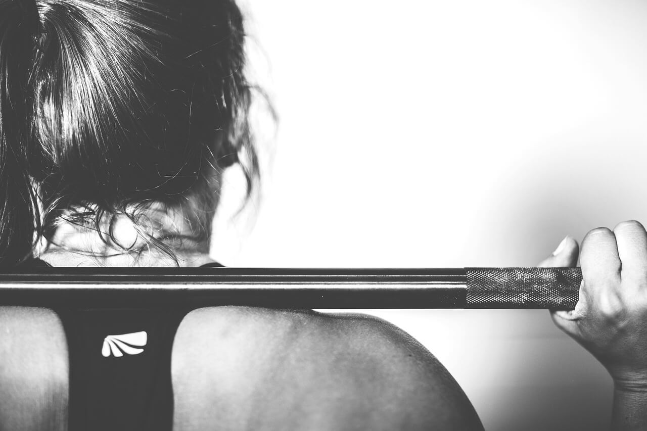 zwart wit foto van een vrouw met een barbell