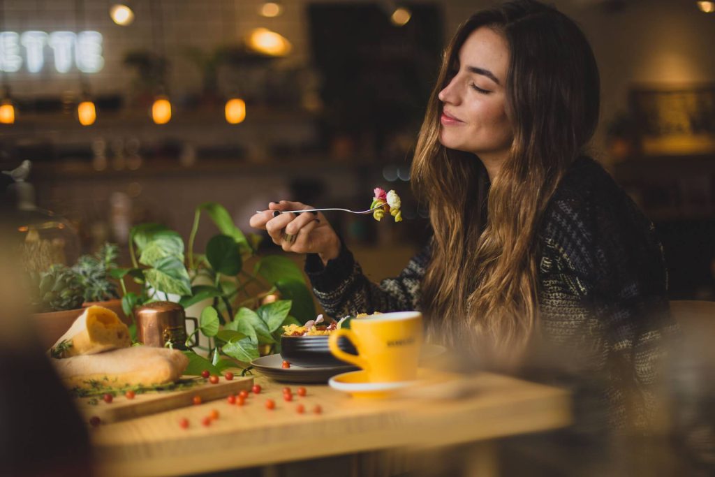 vrouw die een gezonde maaltijd aan het eten is