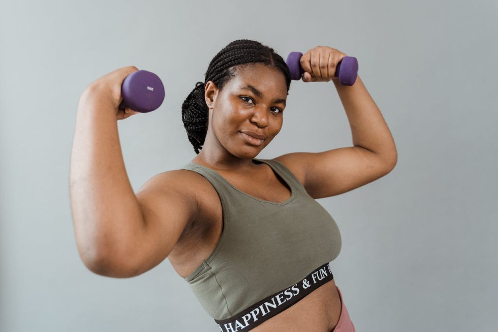 Vrouw aan het sporten met dumbbells