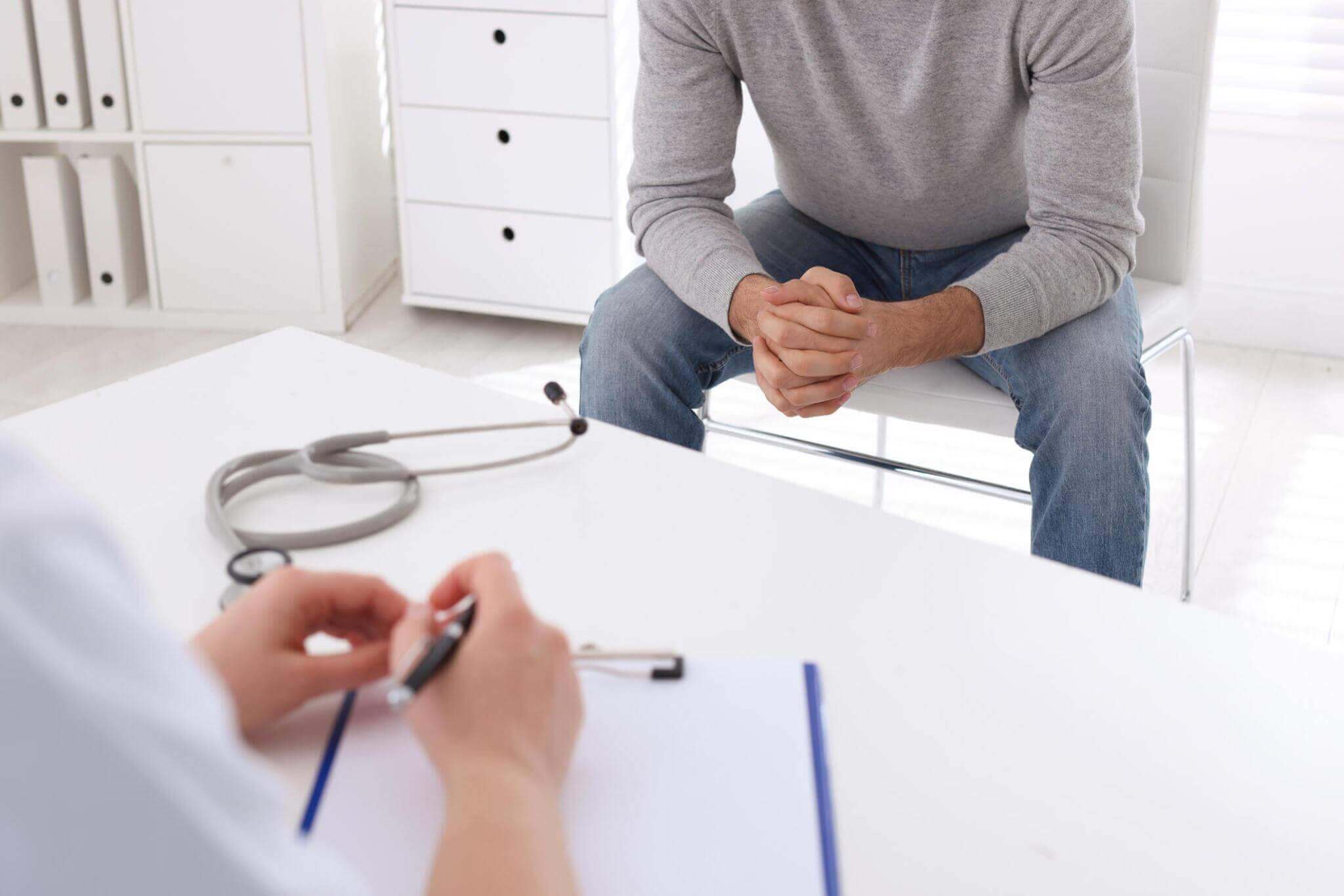 bezoek aan de dokter door man met grijs shirt in verband met een soa
