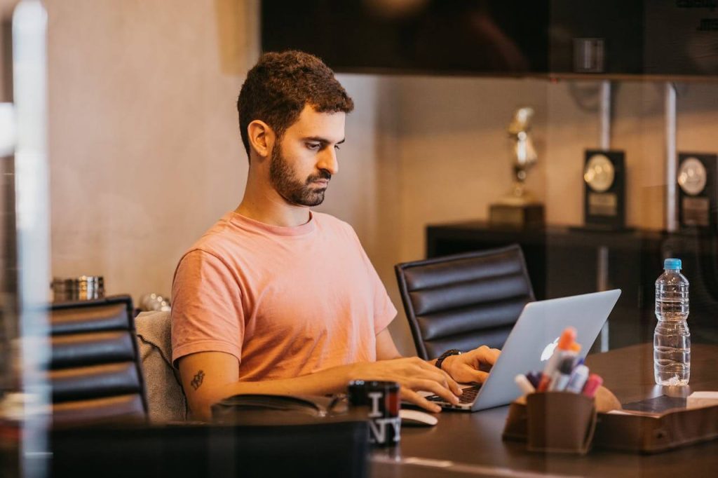 Man let op houding achter de laptop om fit te blijven op kantoor