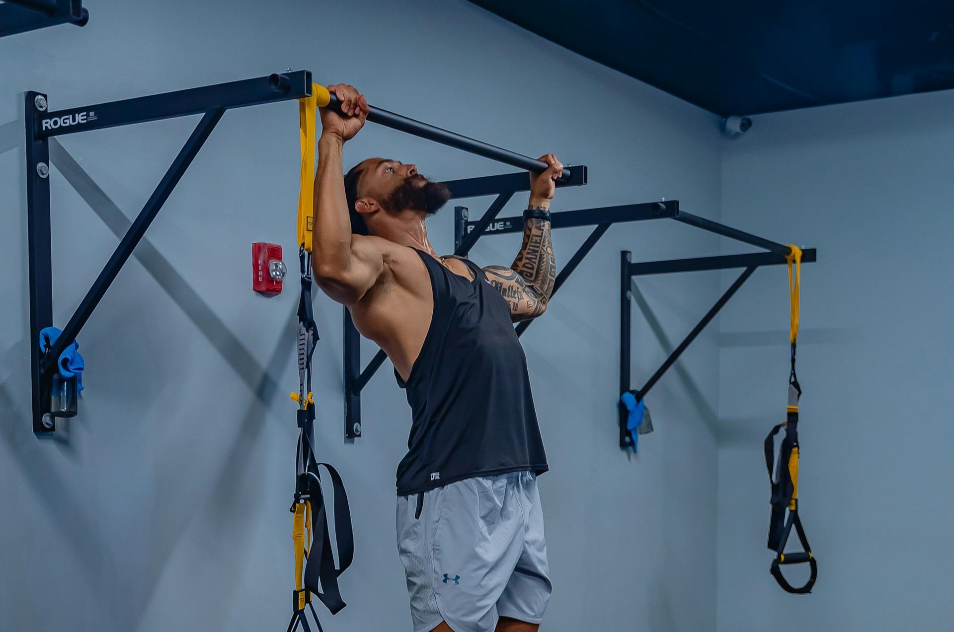 Man traint op pull-up bar aan de muur