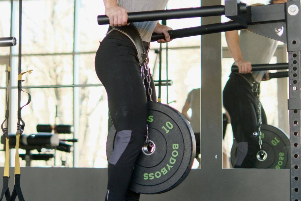 man in de sportschool met een dipping belt