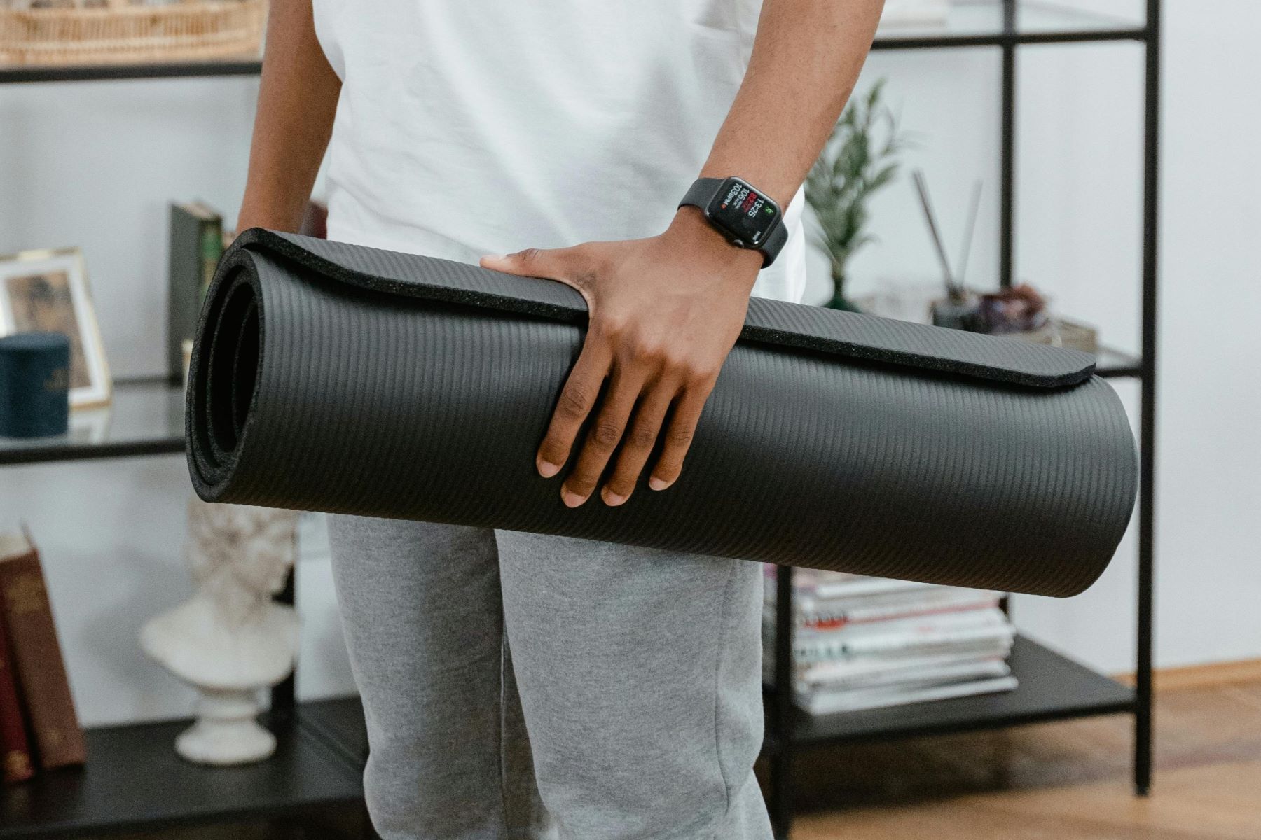 Man houdt opgerolde fitnessmat vast