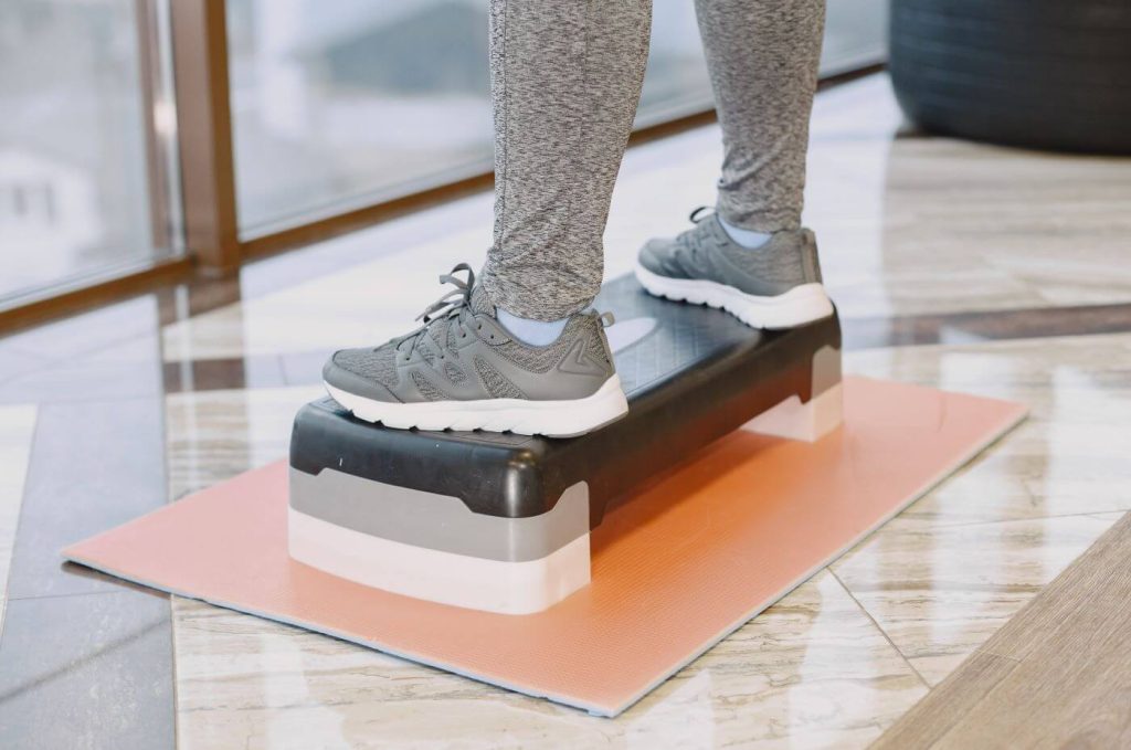 persoon staat op een aerobic steps in de sportschool