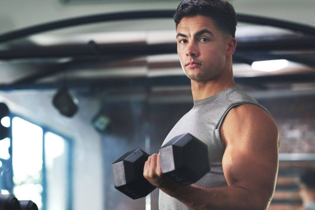 Man traint biceps met dumbbell omdat hij geen spierpijn heeft