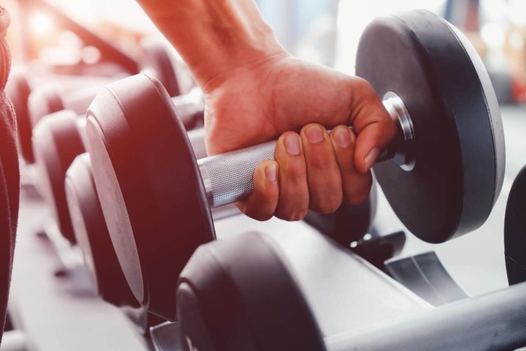 Hand grijpt een dumbbell vast