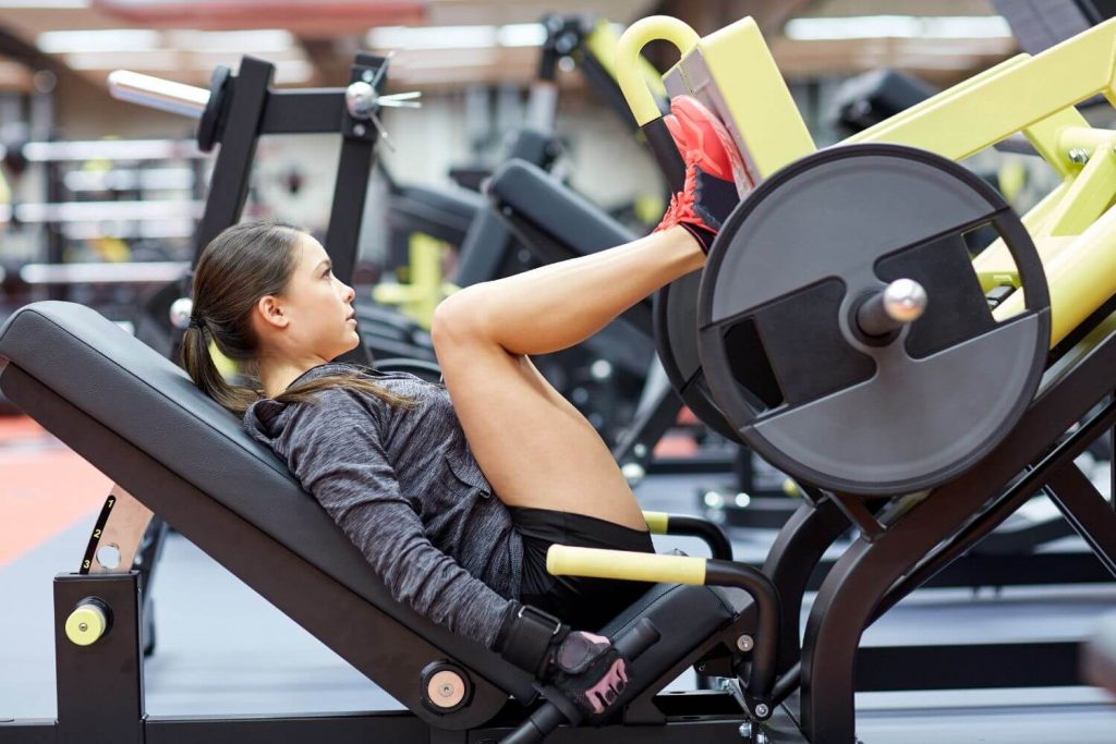 Fitte vrouw traint op een leg press machine