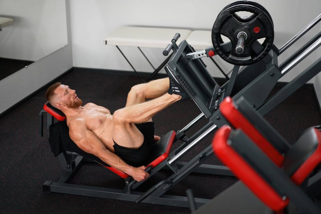 Gespierde man traint op een leg press machine