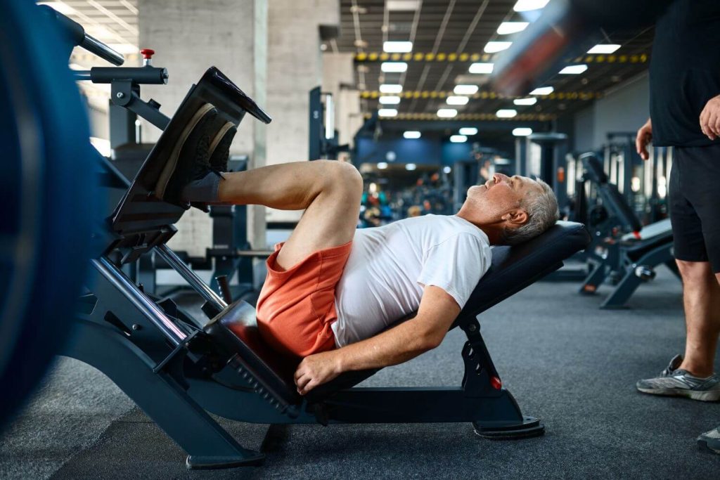 Man aan het trainen in een sportschool op een leg press machine