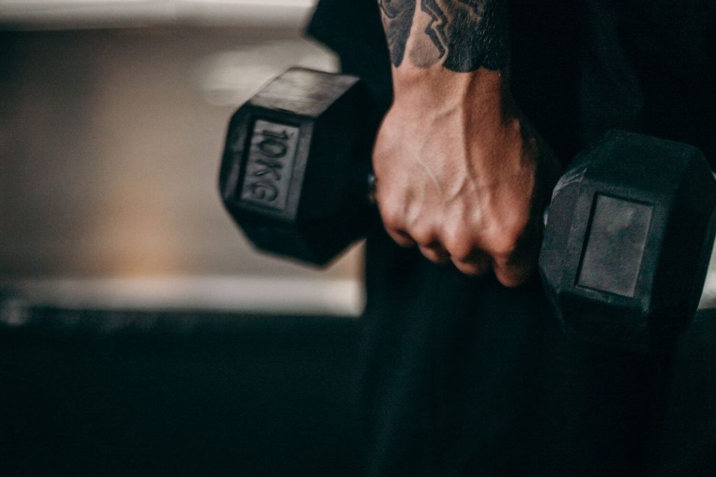 Persoon grijpt een 10kg dumbbell vast