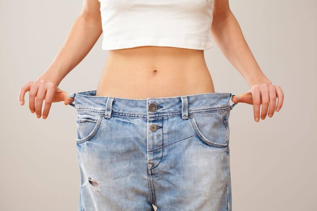 vrouw draagt te grote broek omdat ze veel is afgevallen