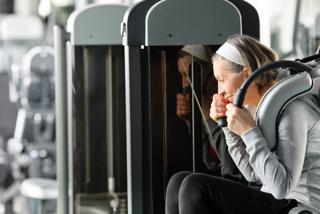 Uitvoering van de ab crunch machine door een vrouw