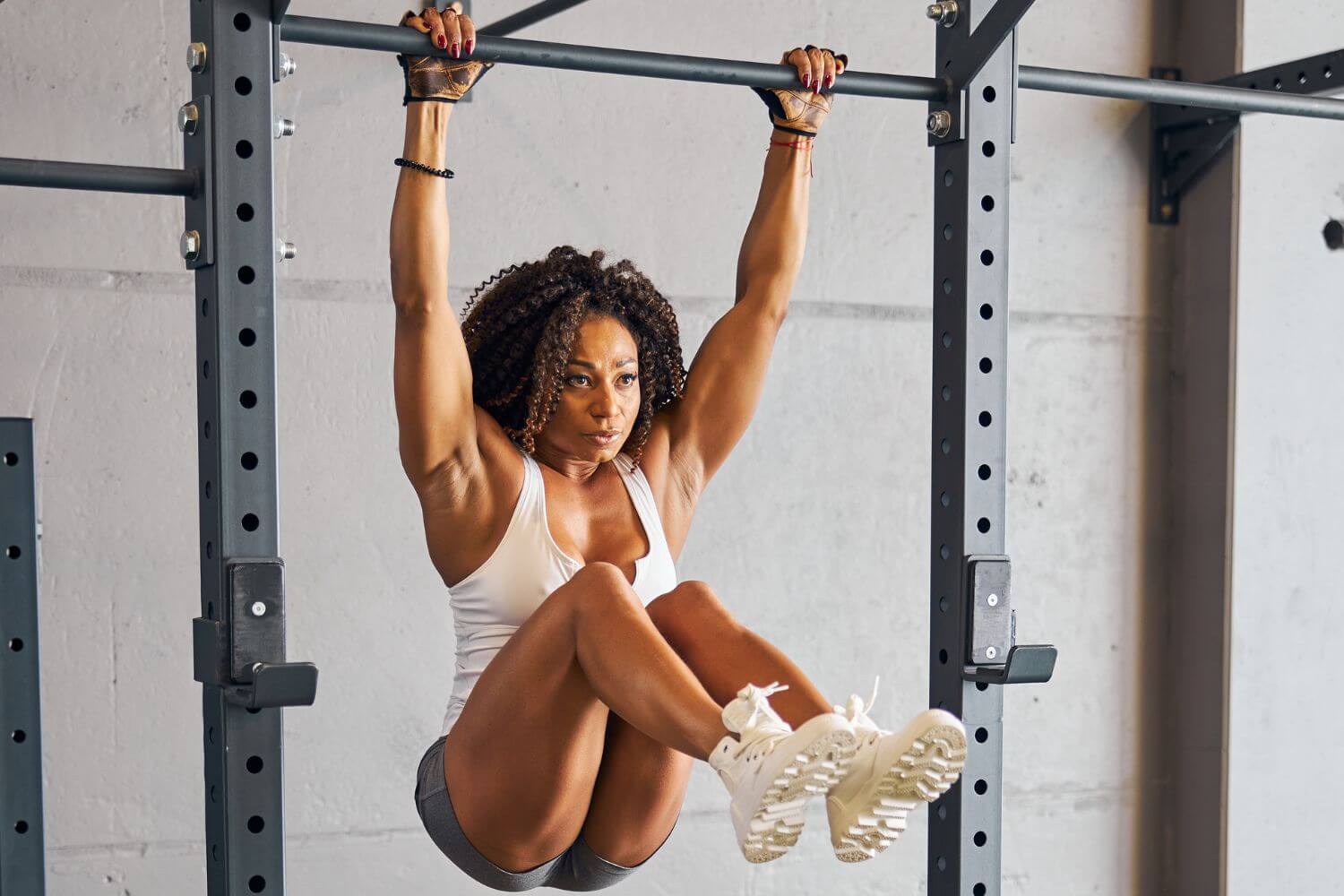 Vrouw doet hanging knee raises in de sportschool