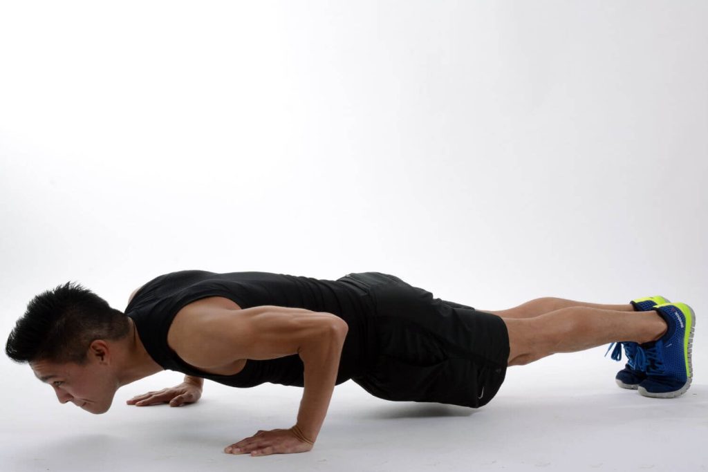 man in zwarte outfit doet een close grip push-up