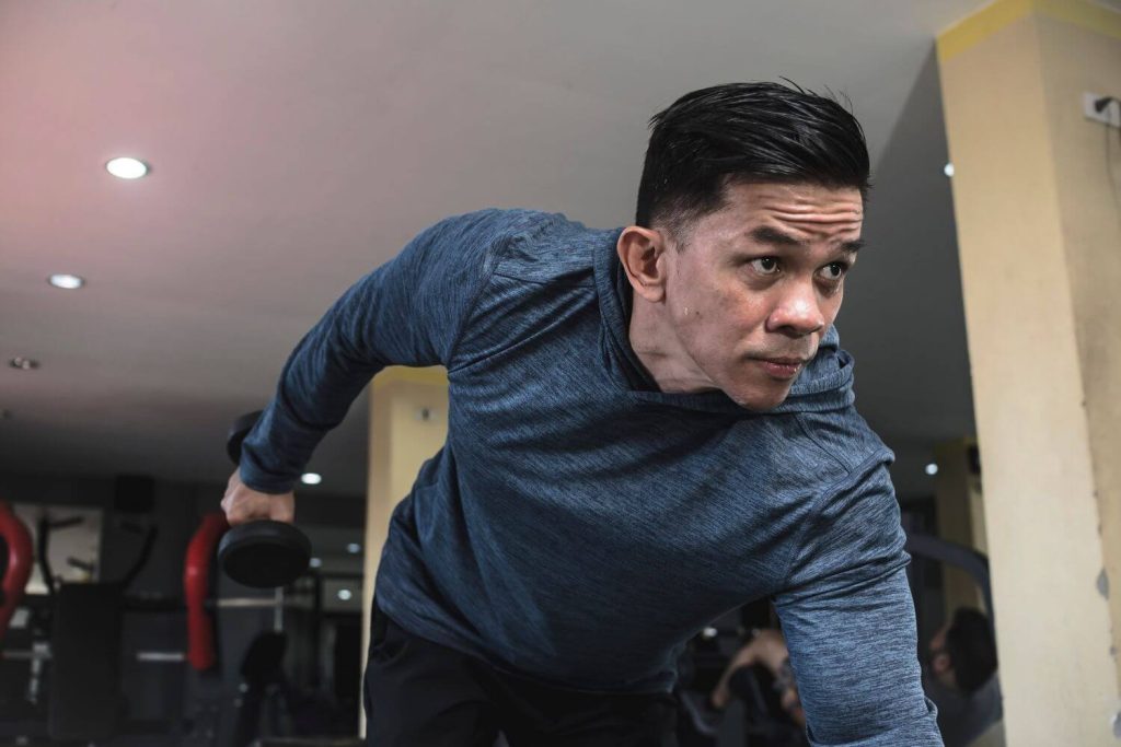 Man voert een triceps kickback uit in de sportschool
