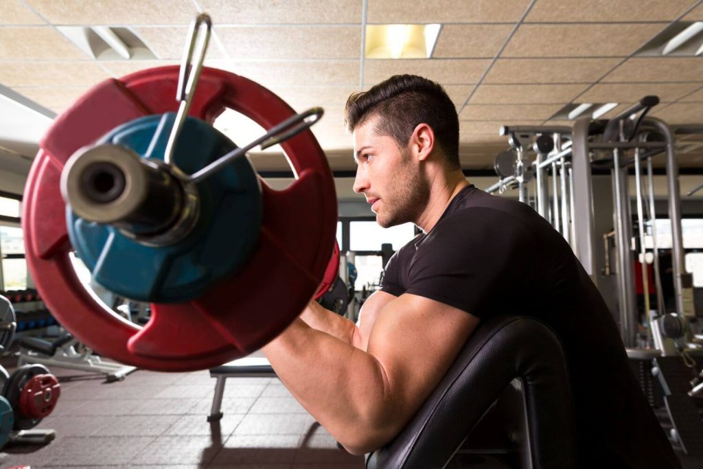Man doet een barbell preacher curl