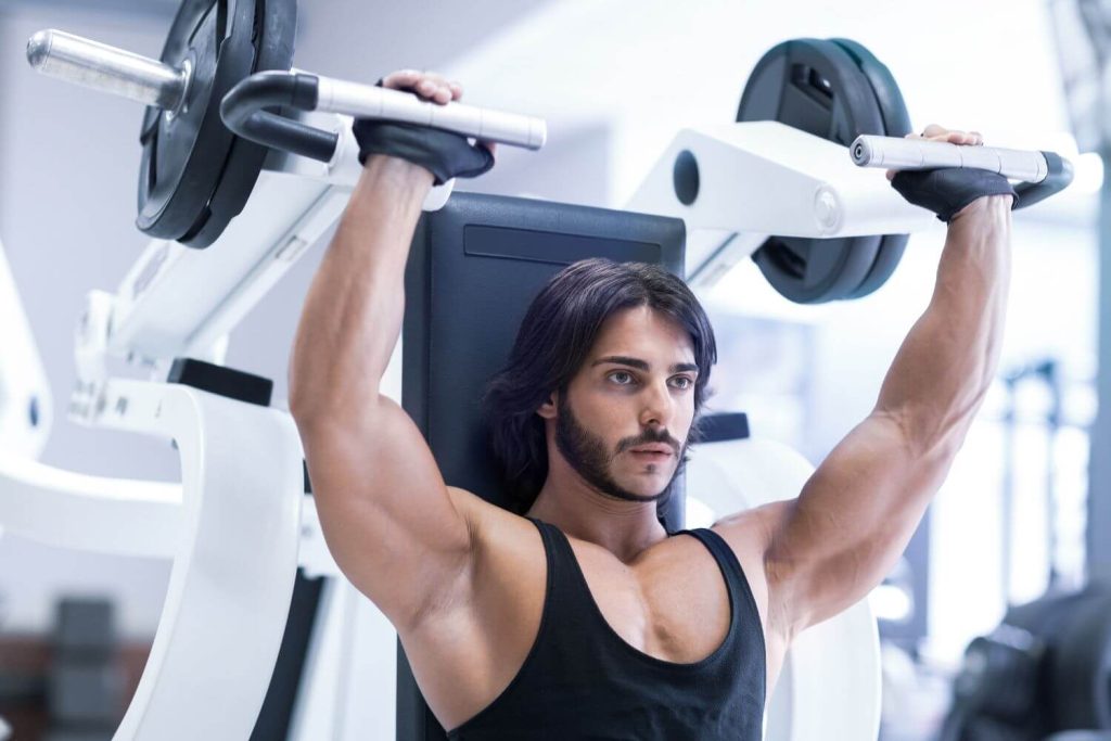 Man voert een machine shoulder press uit