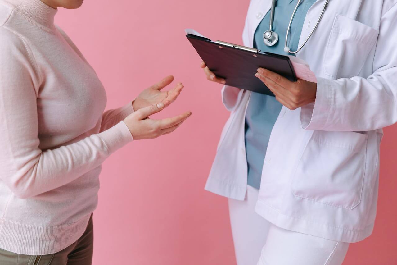 Patient in gesprek met een dokter in witte jas