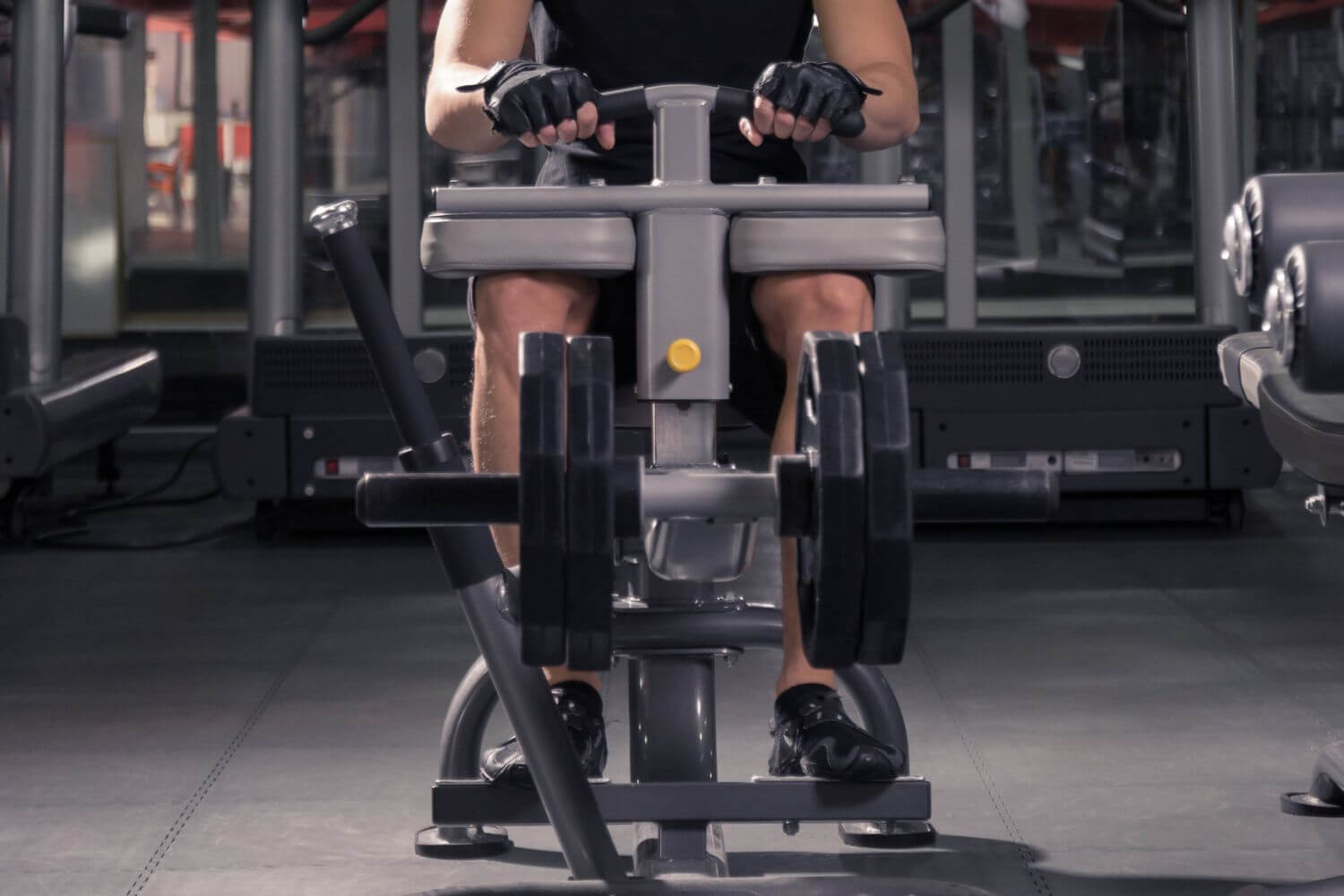 Man op een seated calf raise machine